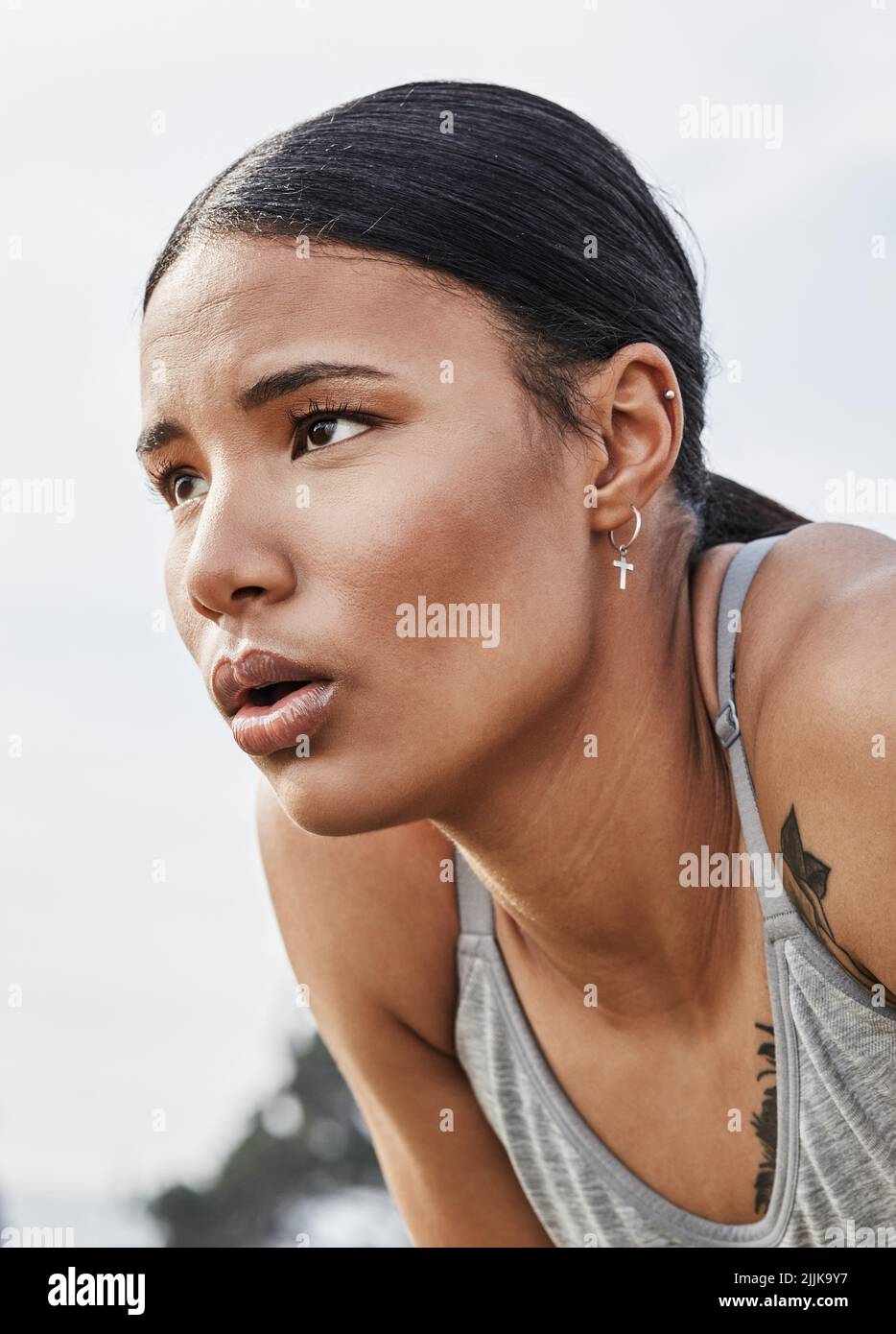 Yes its tough, but so are you. a young woman catching her breath while exercising outdoors. Stock Photo