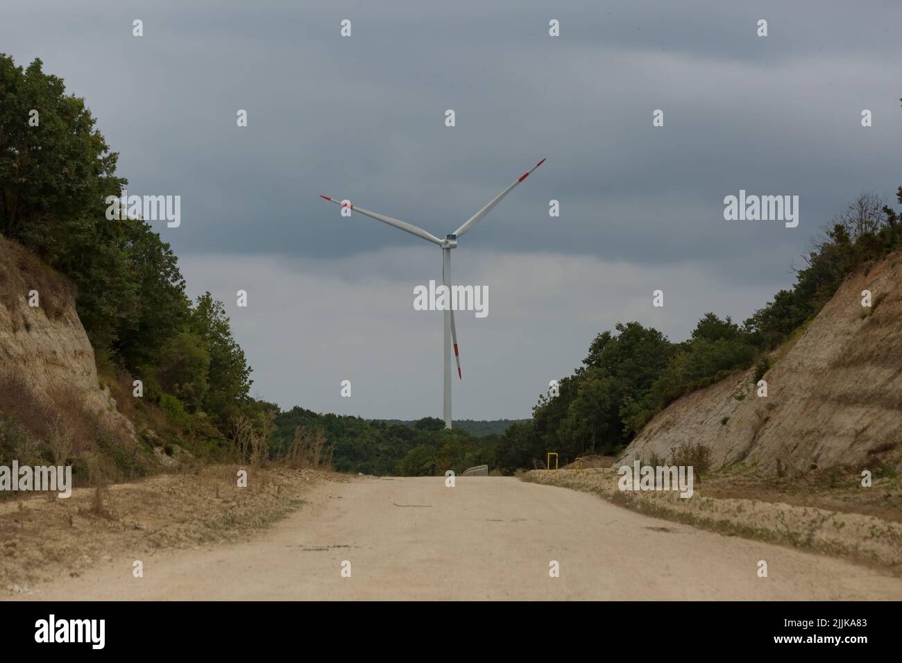 Wind turbine raising from middle of the forest. Near to Black Sea region of Turkey. Road to power plant is the future of renewable energy. Stock Photo