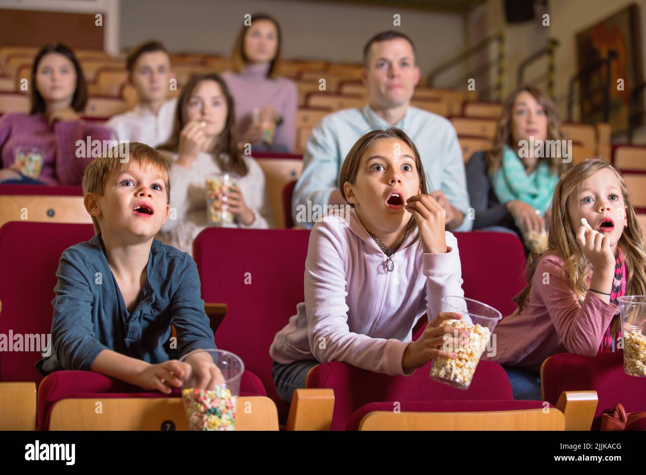 Number of people enjoying film screening and popcorn Stock Photo