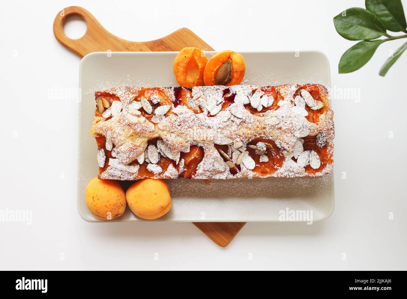 Homemade rectangular shortbread pie with apricots and plums. White ...
