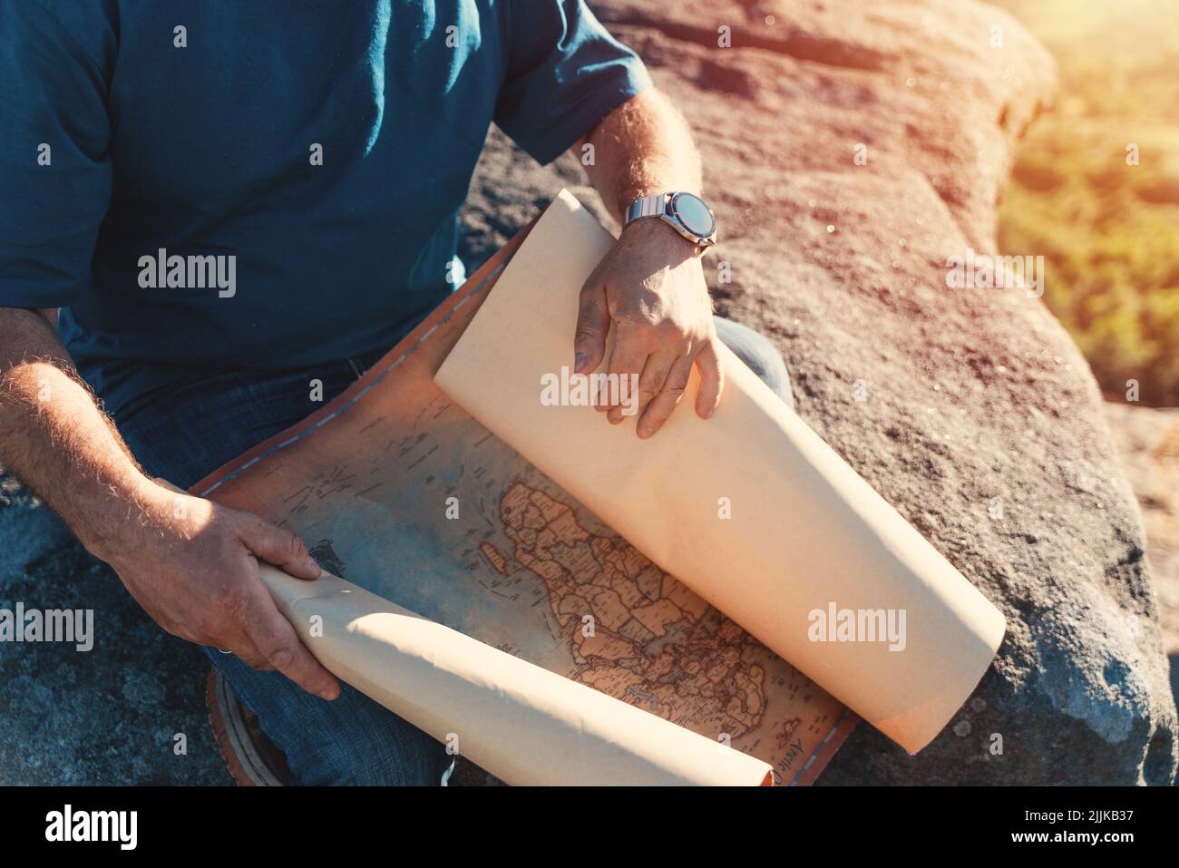 bearded retired man is looking for a destination on the map against the background of fields Stock Photo