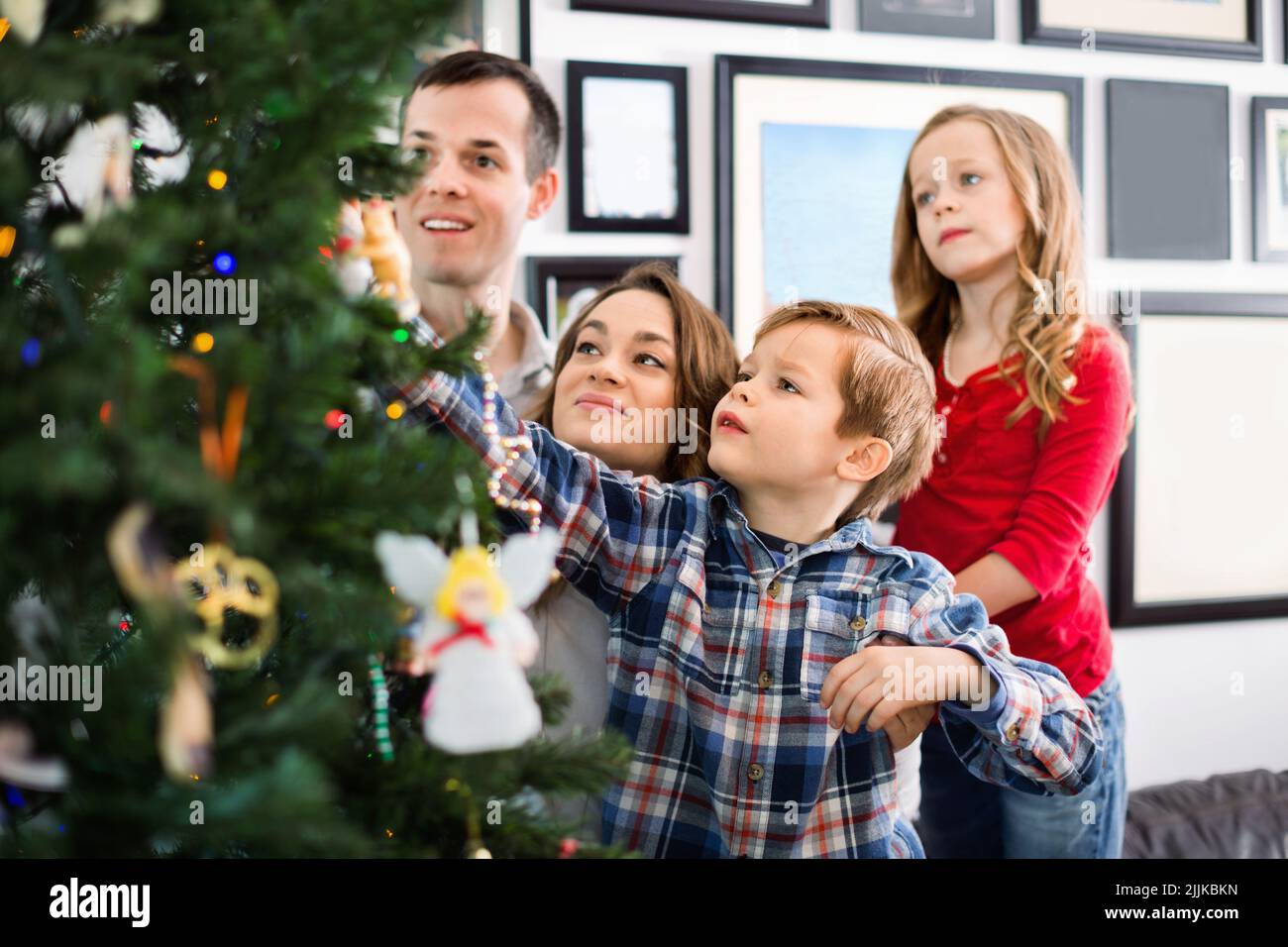 Family decorating Christmas tree at home Stock Photo