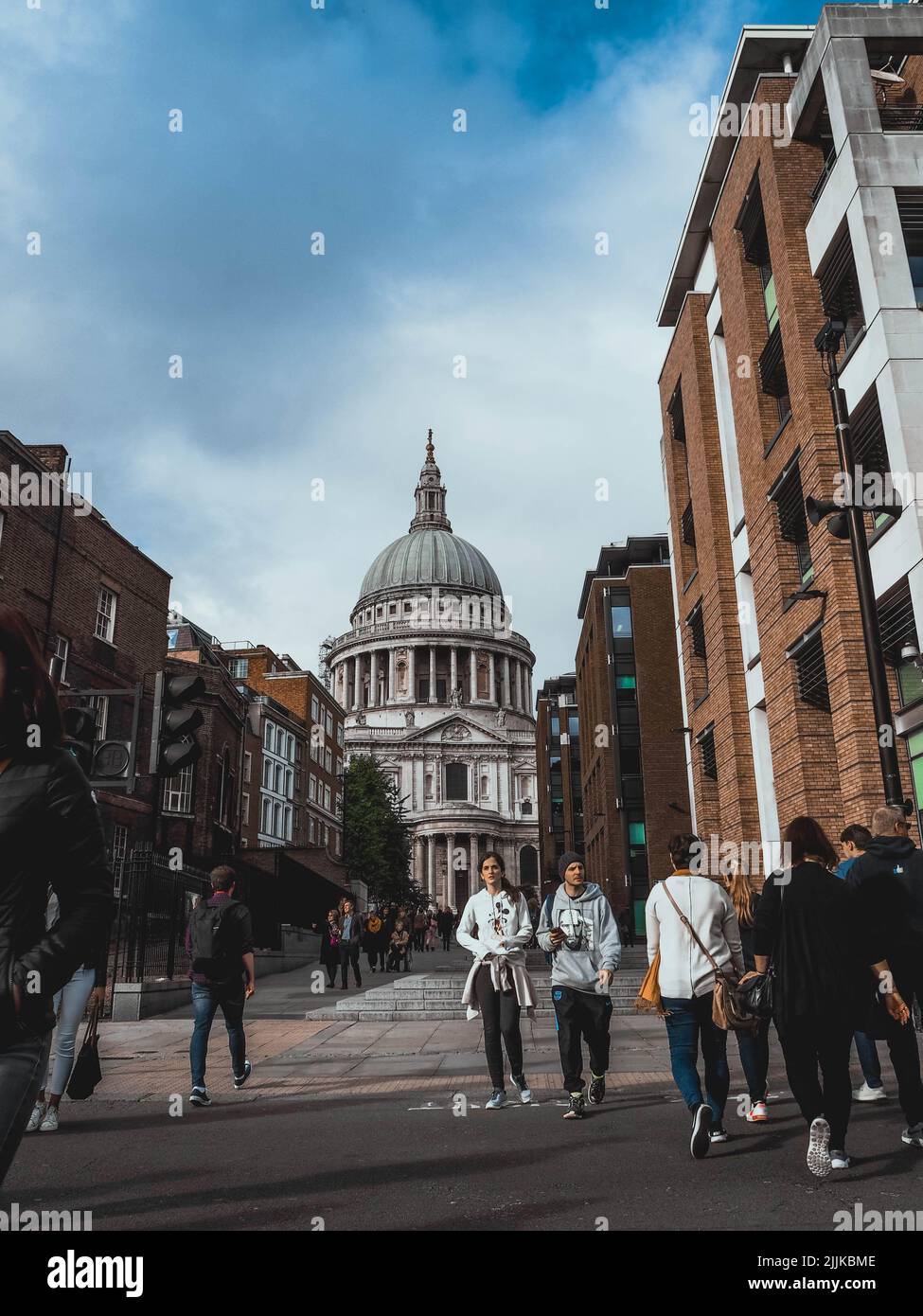 A vertical photo of people near St Paul Cathedral in London Stock Photo