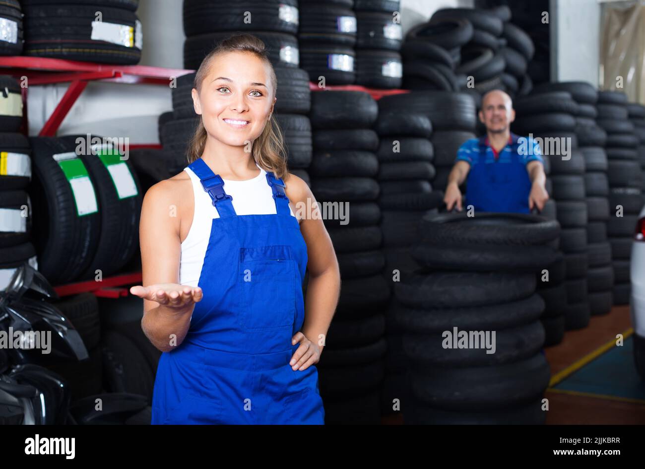 technician woman in overalls standing in car workshop indoors Stock Photo