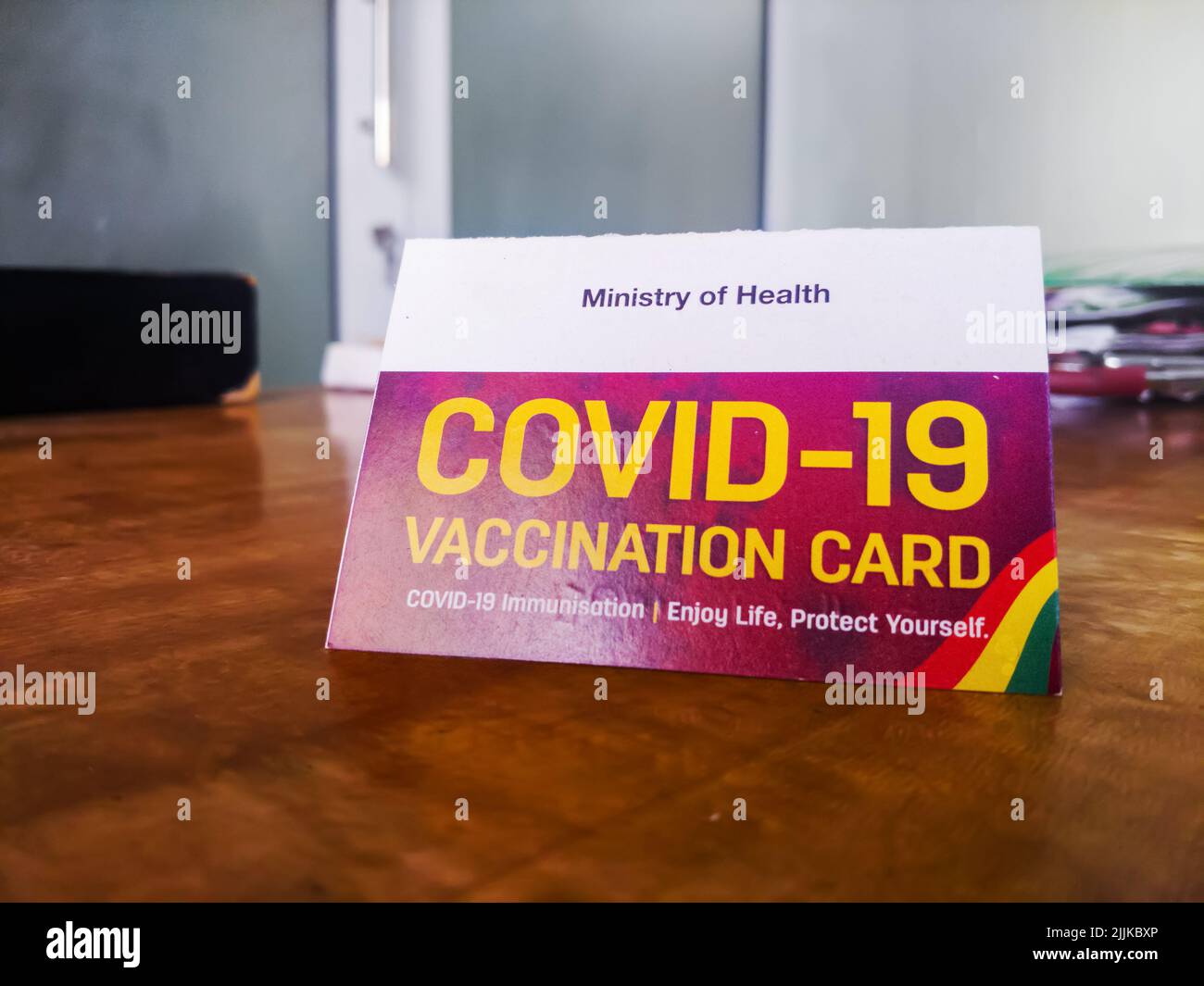 A COVID-19 vaccination card on a table Stock Photo
