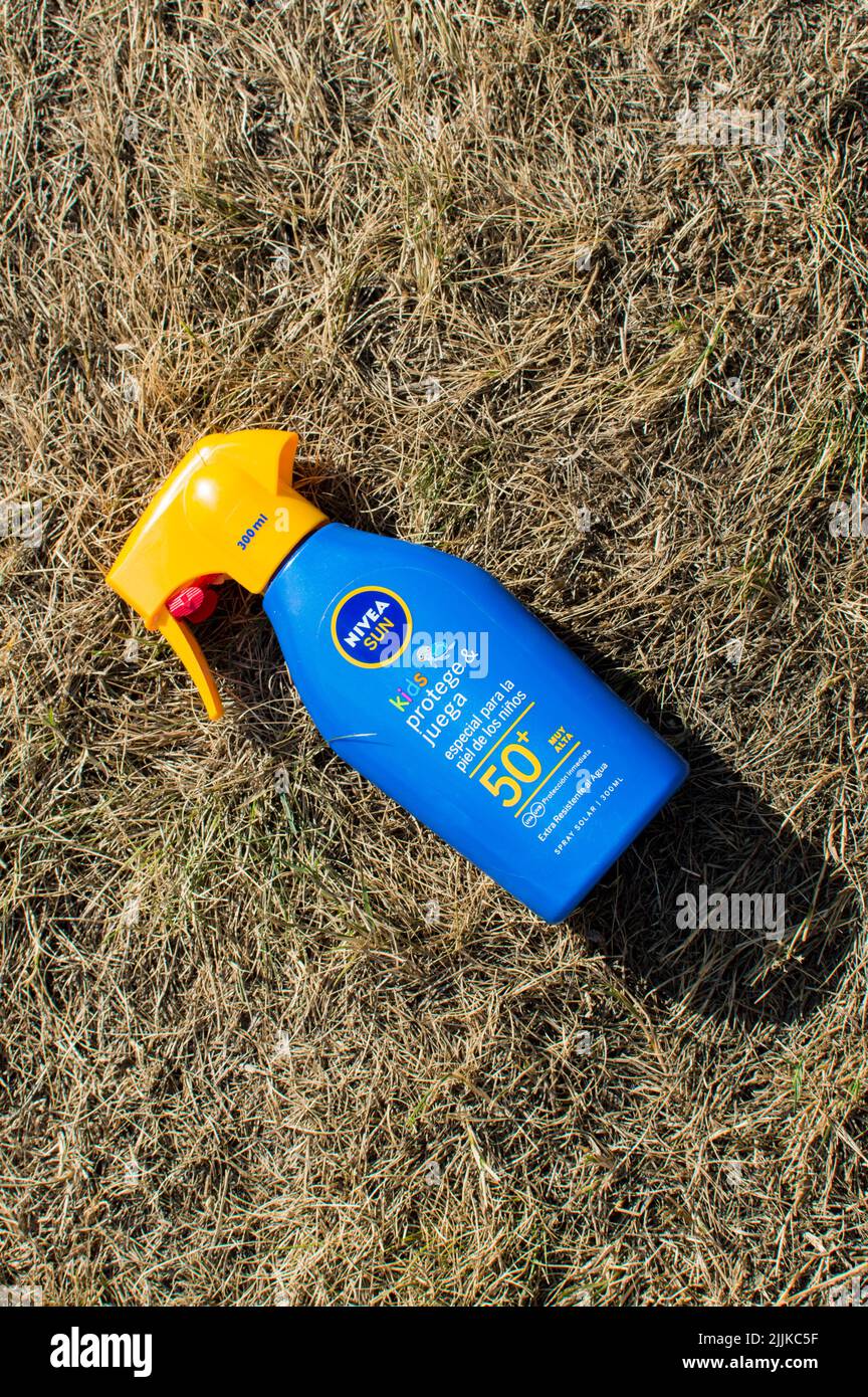Nivea Sun cream on a dry grass indicating extreme weather Stock Photo