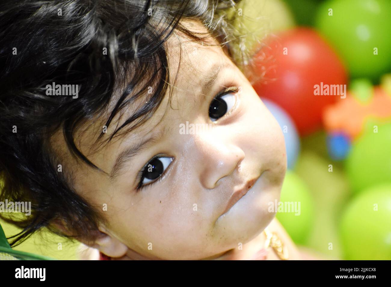 A portrait of a cute little Indian baby with big eyes in the playground Stock Photo