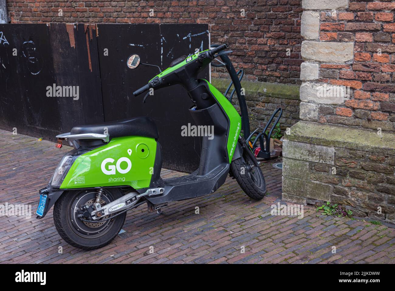 Parked green go sharing scooter in Haarlem, the Netherlands. There are no people in the shot. Stock Photo