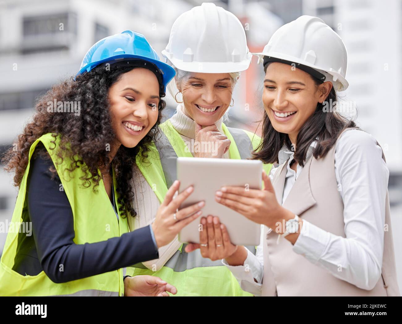 Plans are digital these days. three attractive female engineers using a ...