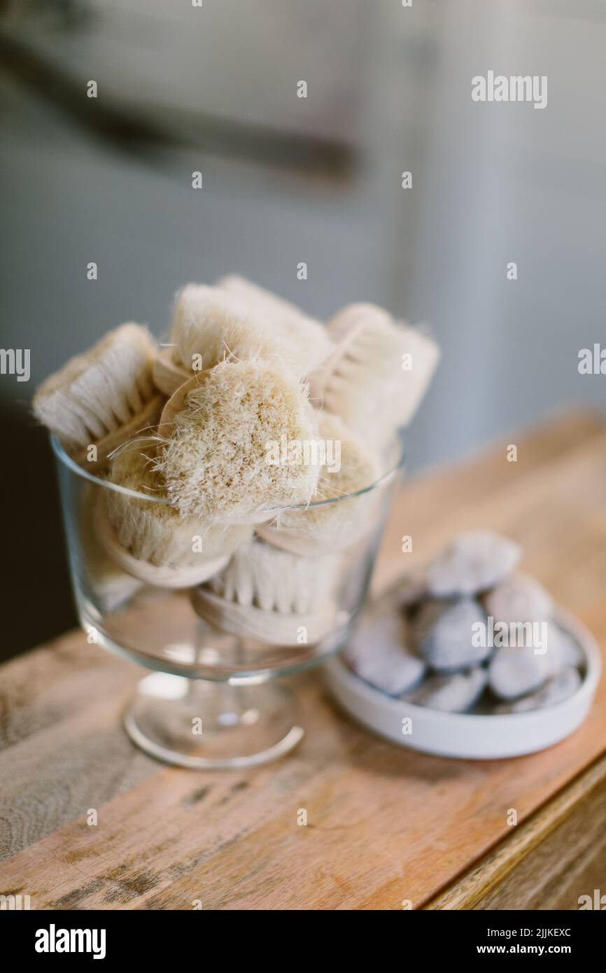 A vertical shot of massaging brushes in a glass on a wooden table. Stock Photo