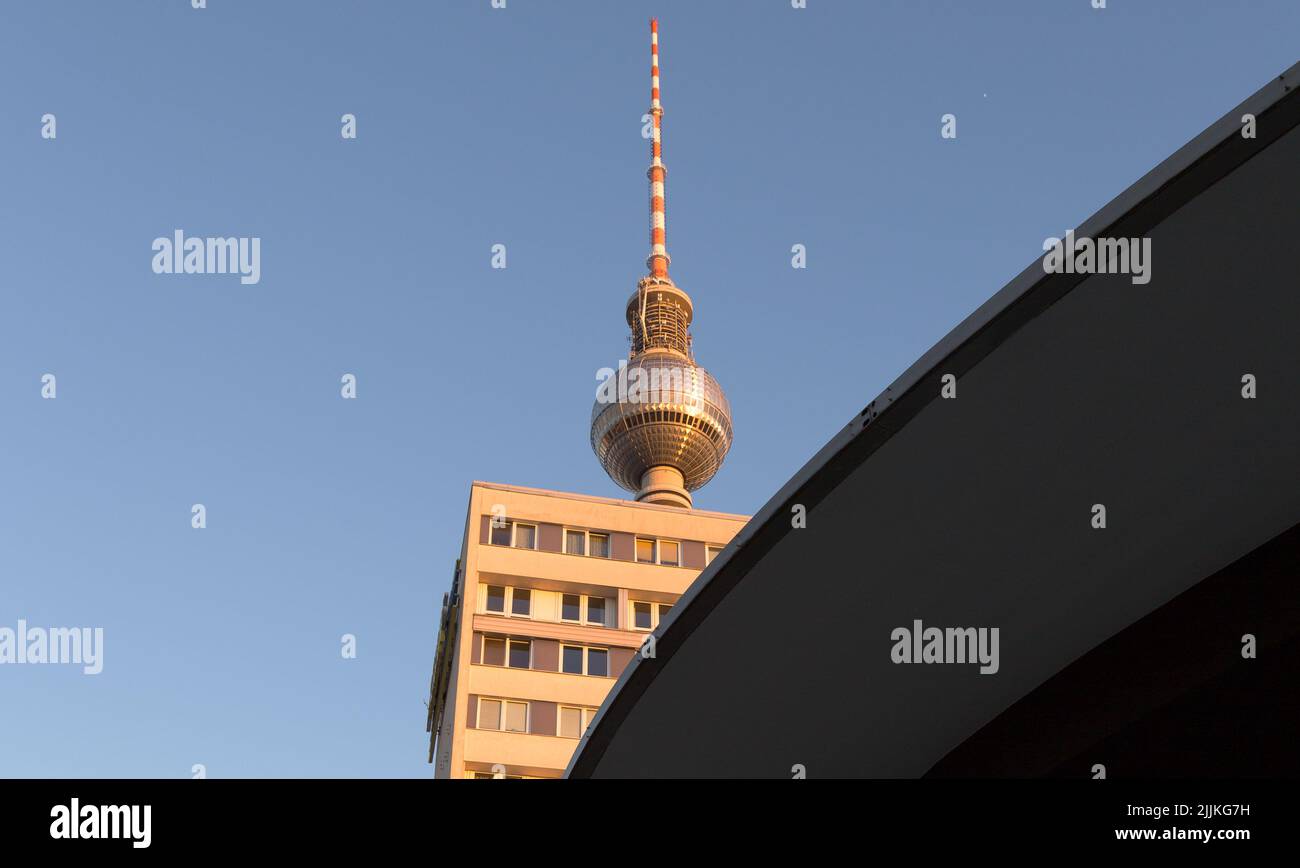 The view of Berliner Fernsehturm in the sunlight behind a building. Berlin, Germany Stock Photo