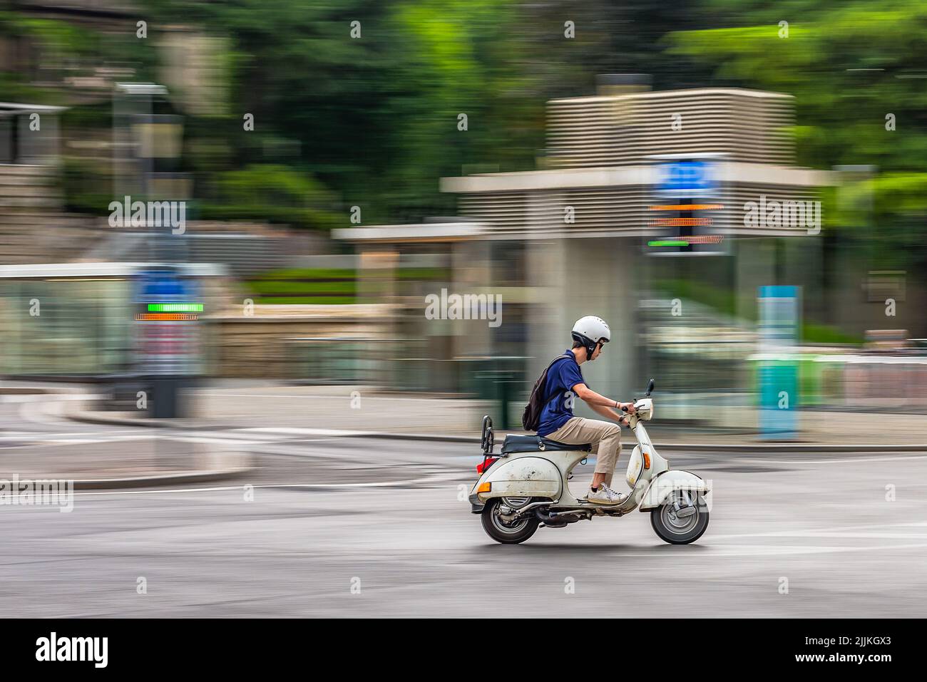 A Vespa scooter goes fast in the city Stock Photo Alamy