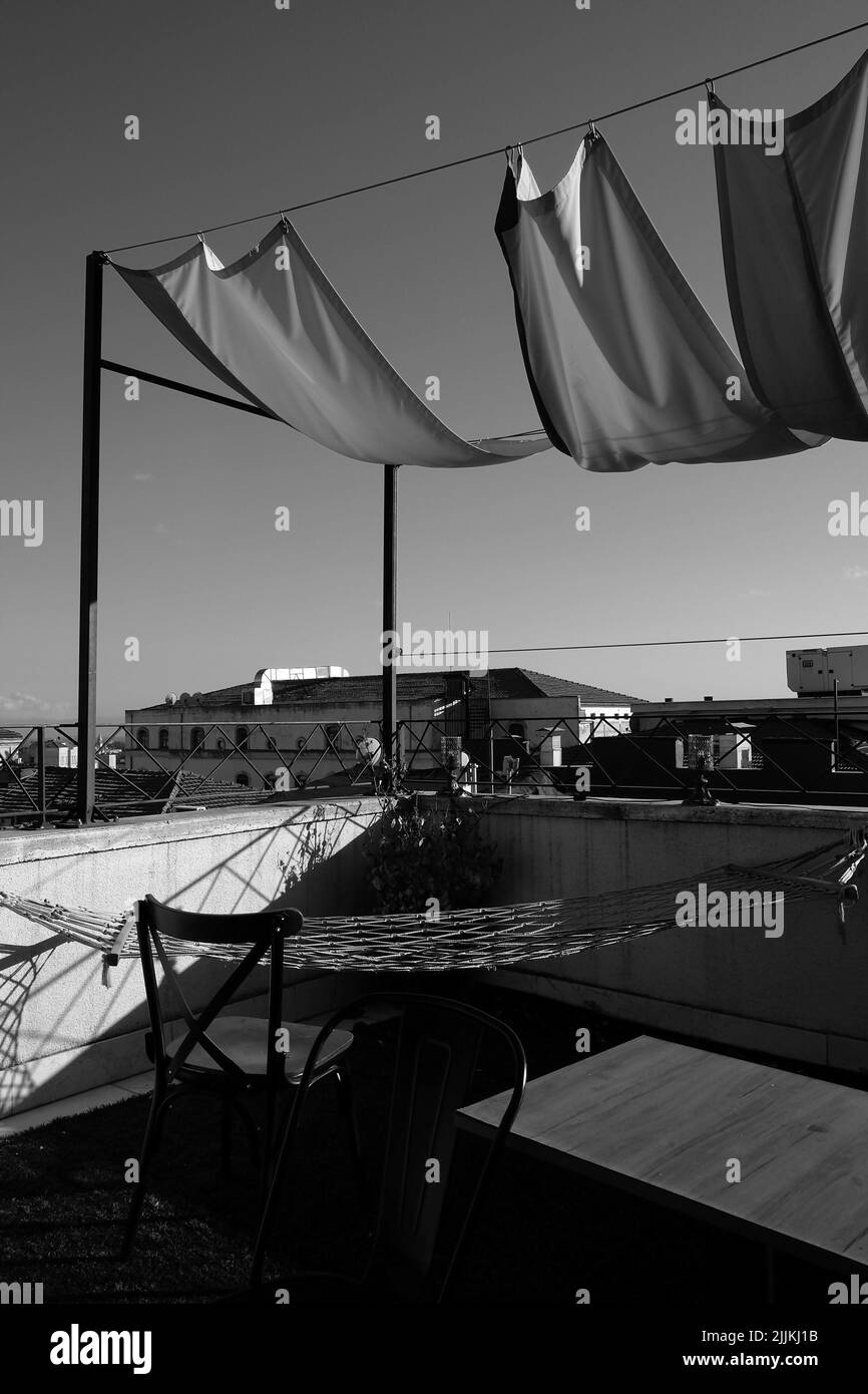 A vertical shot of sun shade nets and hammock in the balcony in black and white Stock Photo