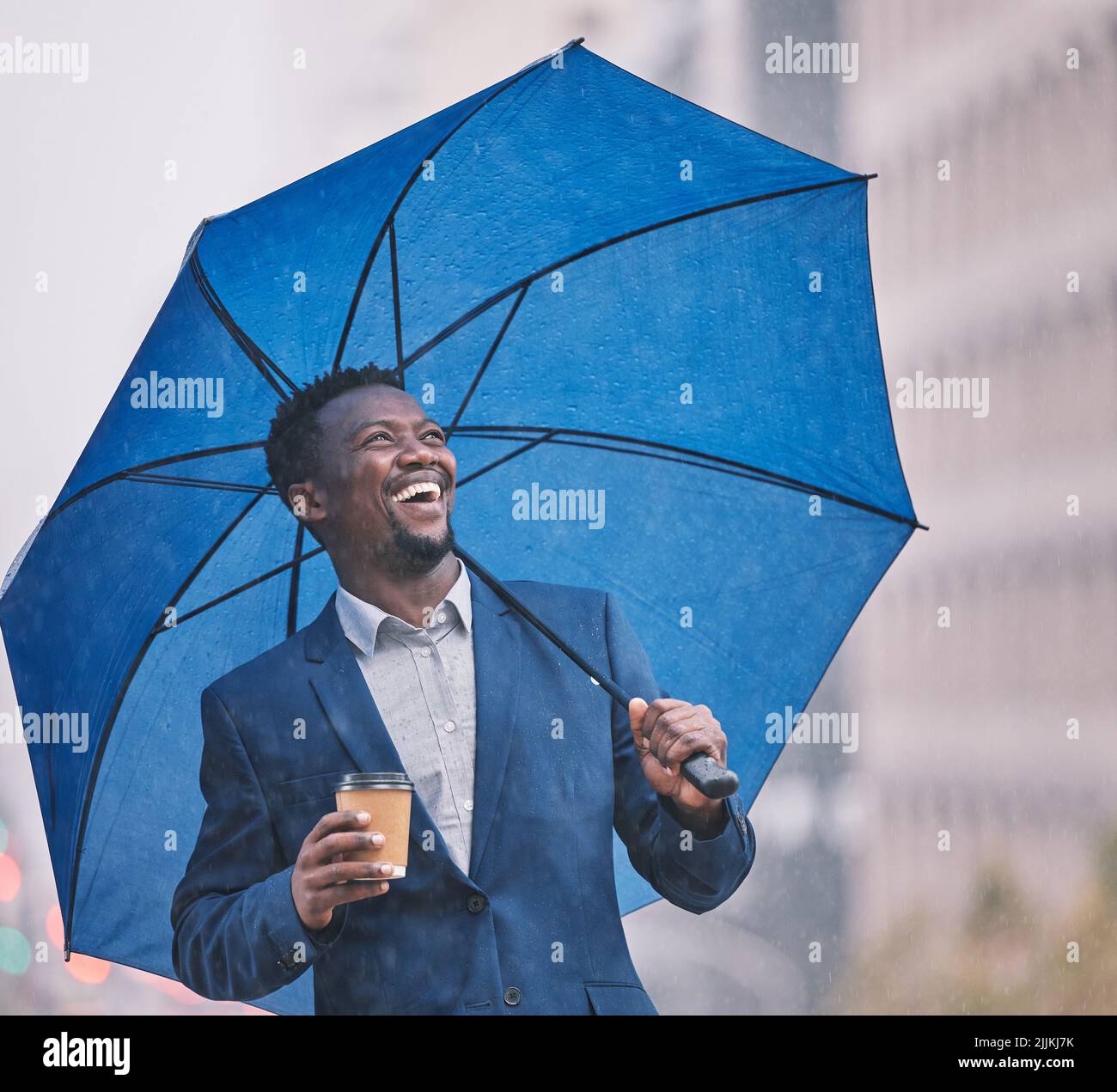 Happy businessman holding umbrella against stormy dark sky with ...