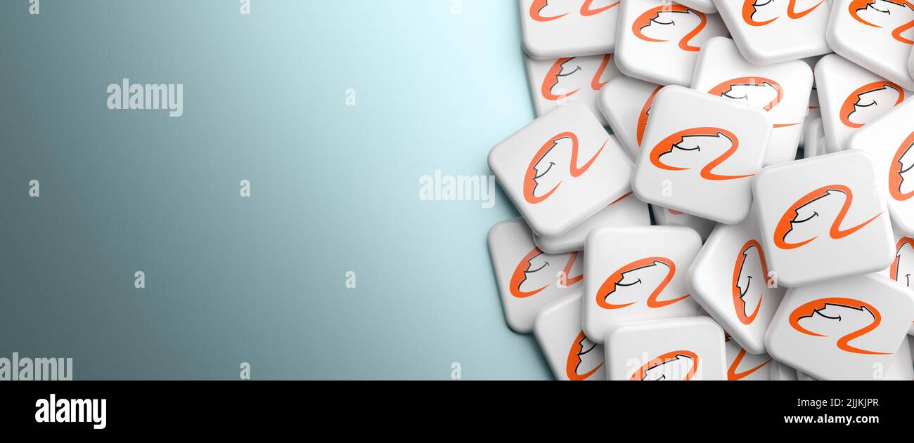 Logos of the chinese ecommerce company Alibaba Group on a heap on a table. Copy space. Web banner format.v Stock Photo