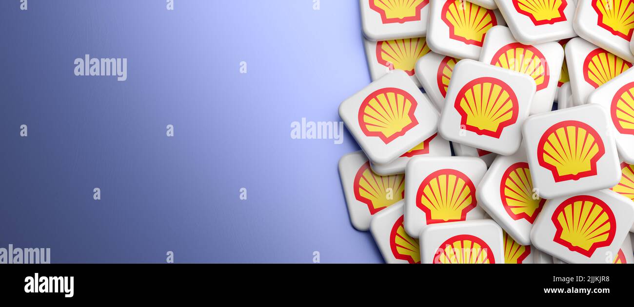 Logos of the oil and gas company Royal Dutch Shell on a heap on a table. Copy space. Web banner format.v Stock Photo