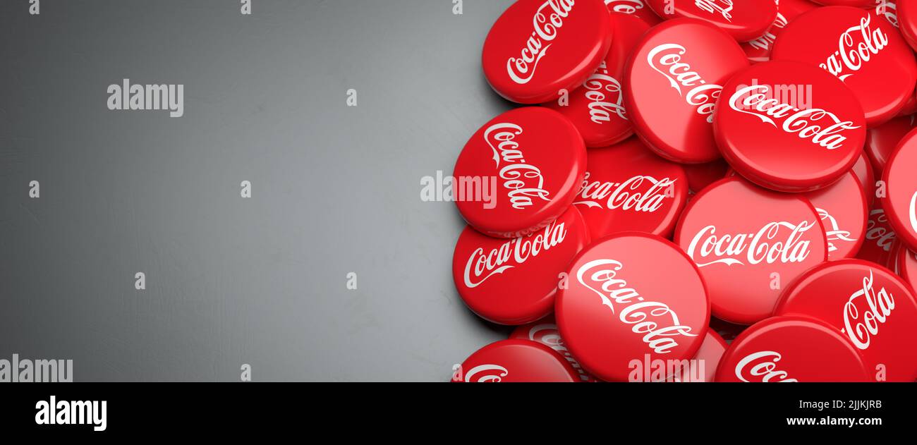 Logos of the beverage company Coca-Cola on a heap on a table. Copy space. Web banner format. Stock Photo