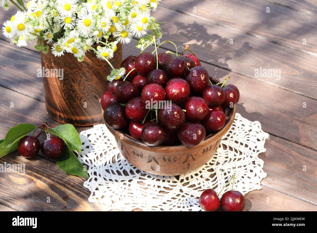 sweet cherries on wooden table in the garden Stock Photo