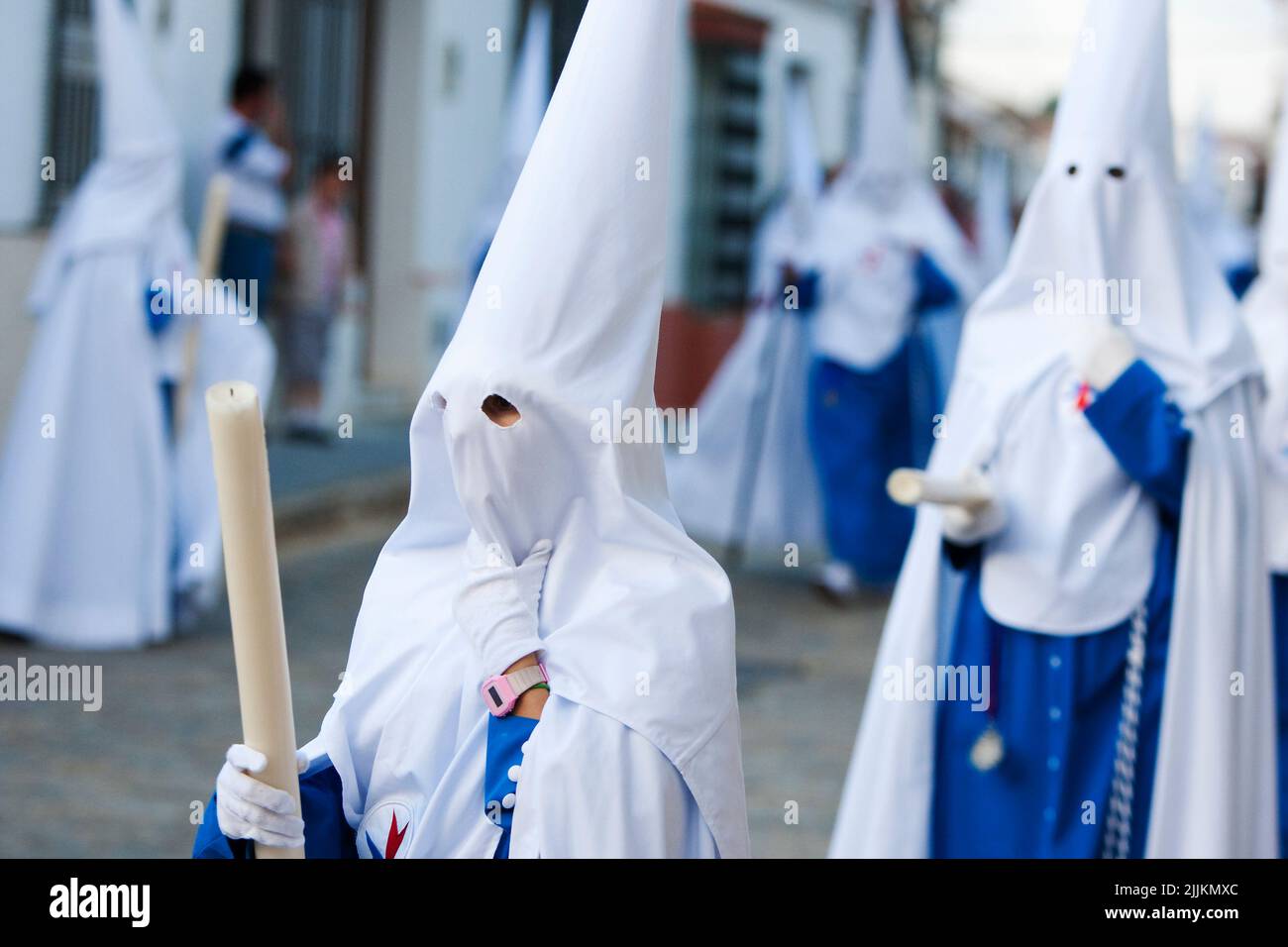 The Spanish Holy Week processions with people wearing white, traditional capirotes Stock Photo