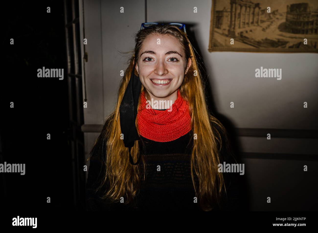 Front shot of a smiling girl looking straight ahead, wearing a red scarf and long loose hair Stock Photo