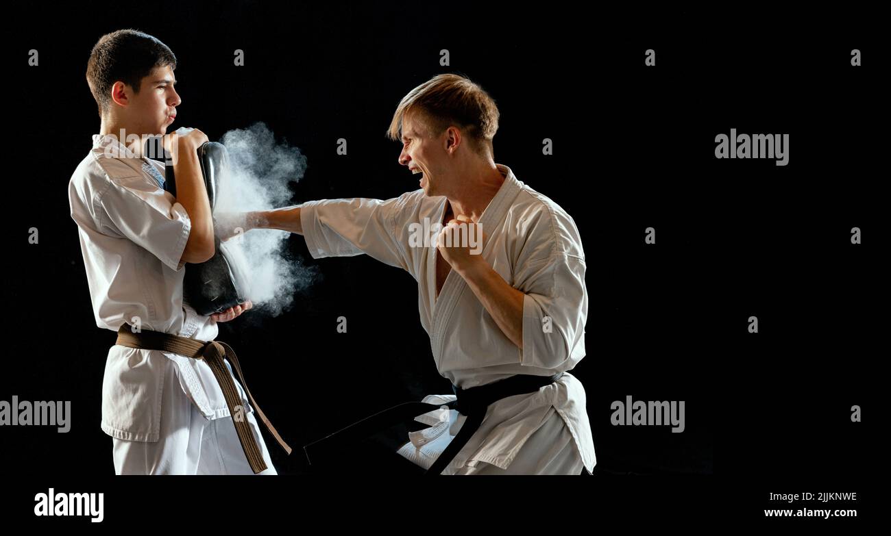 Dynamic portrait of male karate-do fighters in sports uniform training ...