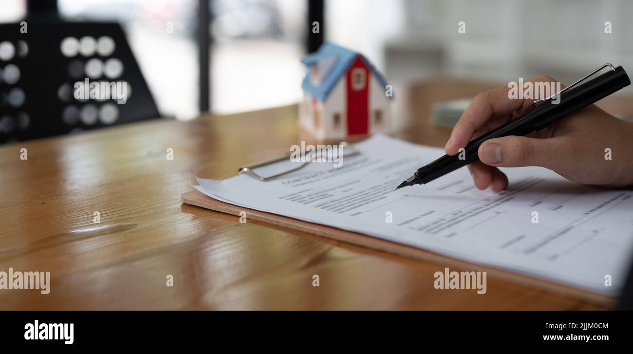 Real estate agent working sign agreement document contract for home loan insurance. Stock Photo