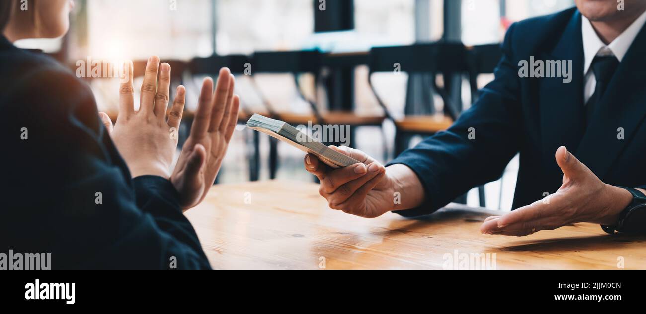 Side view of judge showing stop gesture near client with dollars, anti-corruption concept Stock Photo