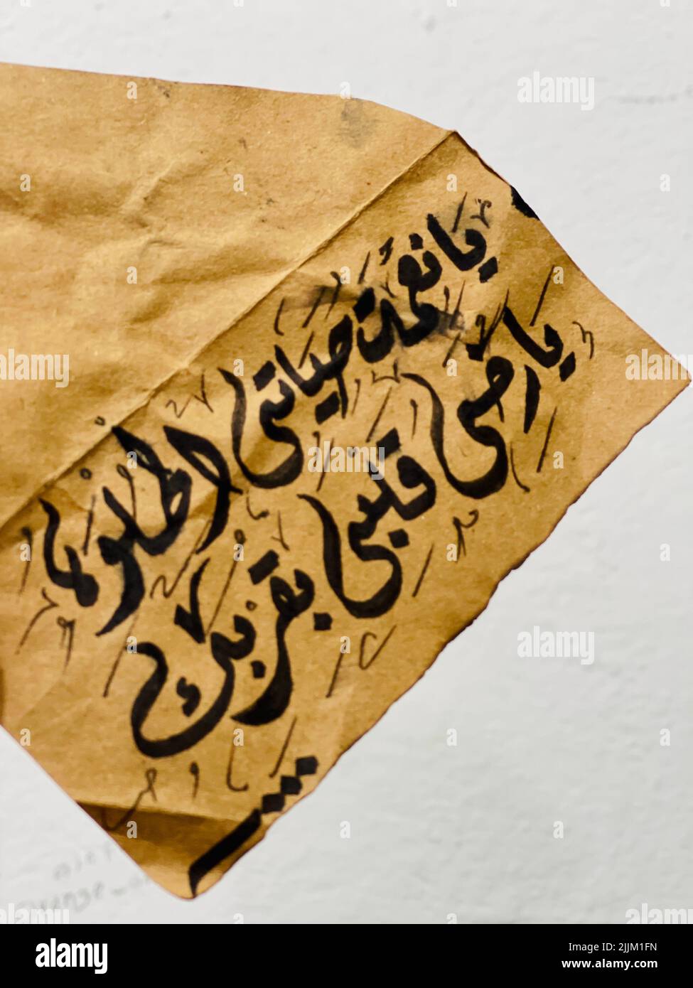 A vertical shot of Arabic calligraphy on an old, vintage paper Stock Photo