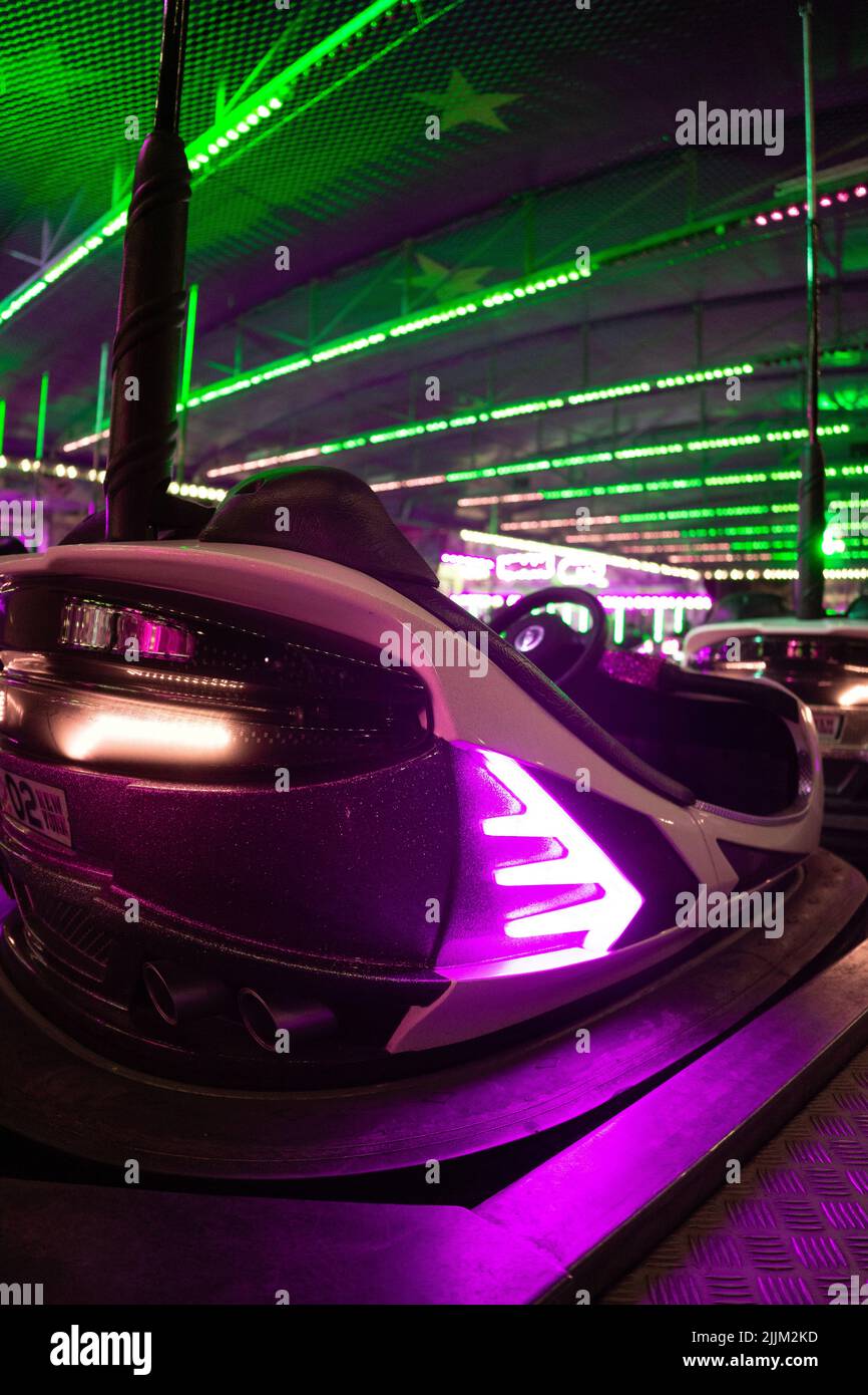 A vertical shot of the back of an illuminated bumper car at a funfair