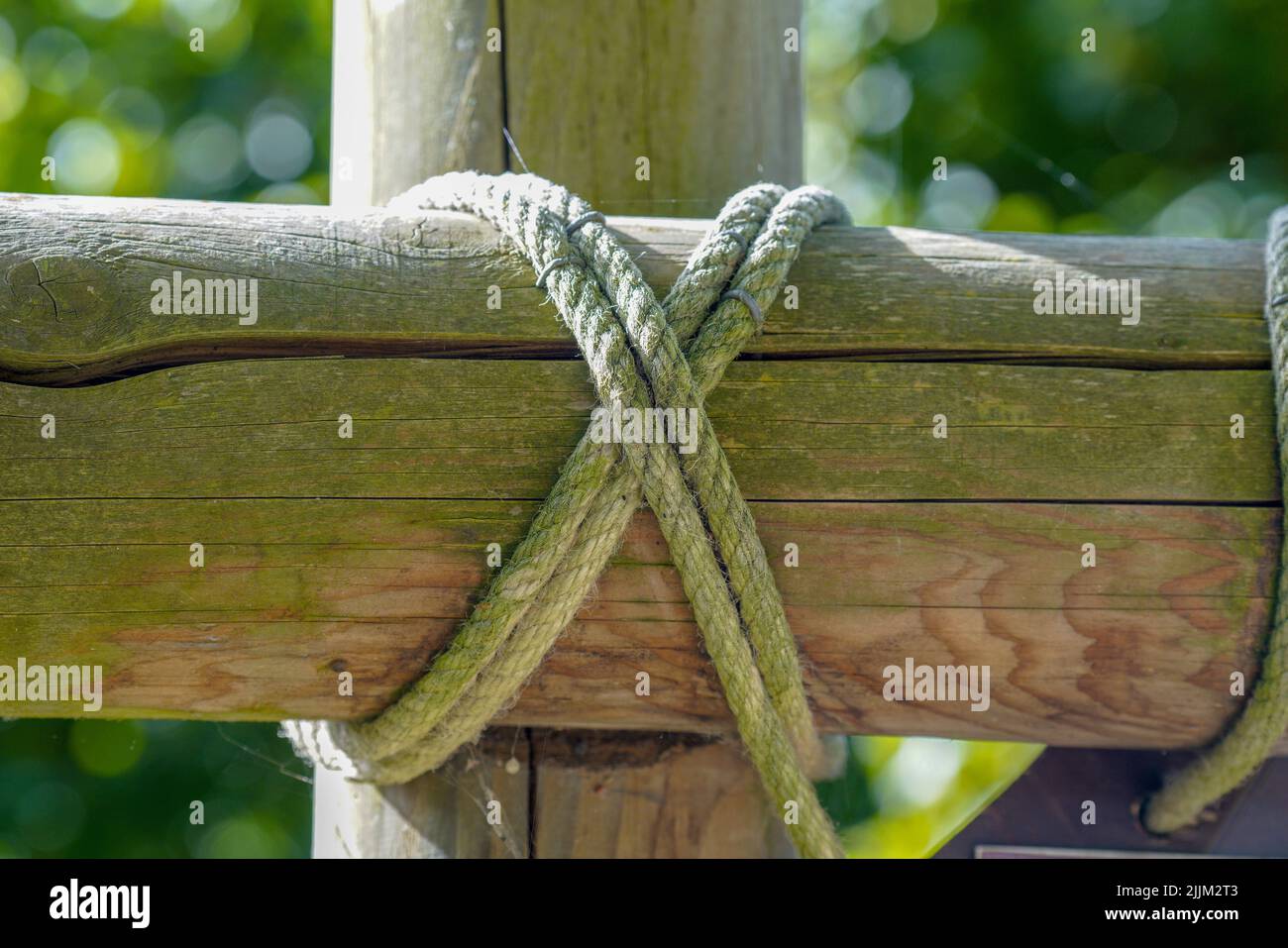 A closeup shot of the wooden fence tied with hemp ropes Stock Photo