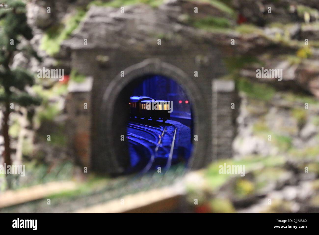 A selective focus shot of a miniature train coming out of a railway tunnel in the 'Miniatur Wunderland' museum, Hamburg, Germany Stock Photo