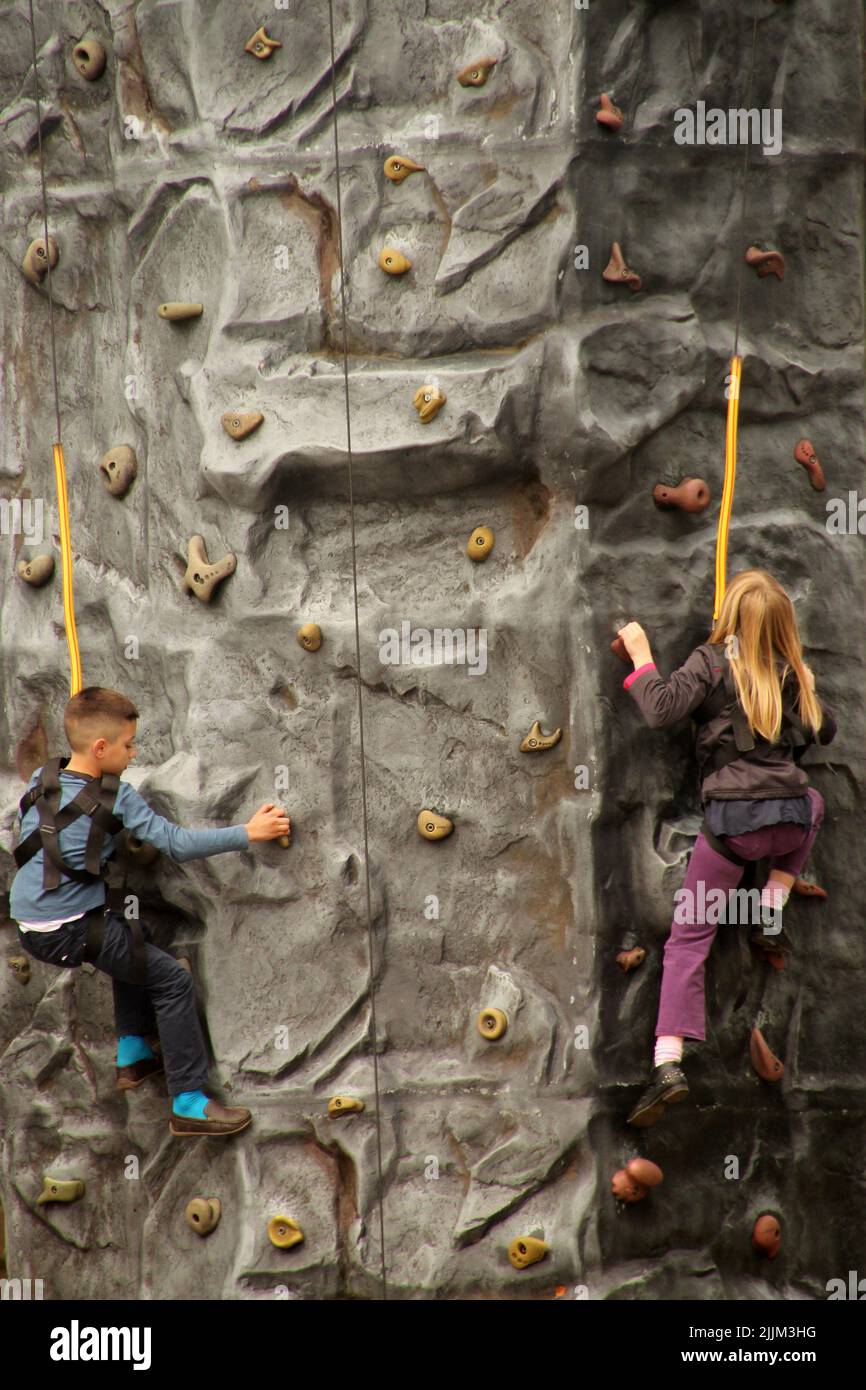 A shot of two kids climbing a wall in the sport club Stock Photo