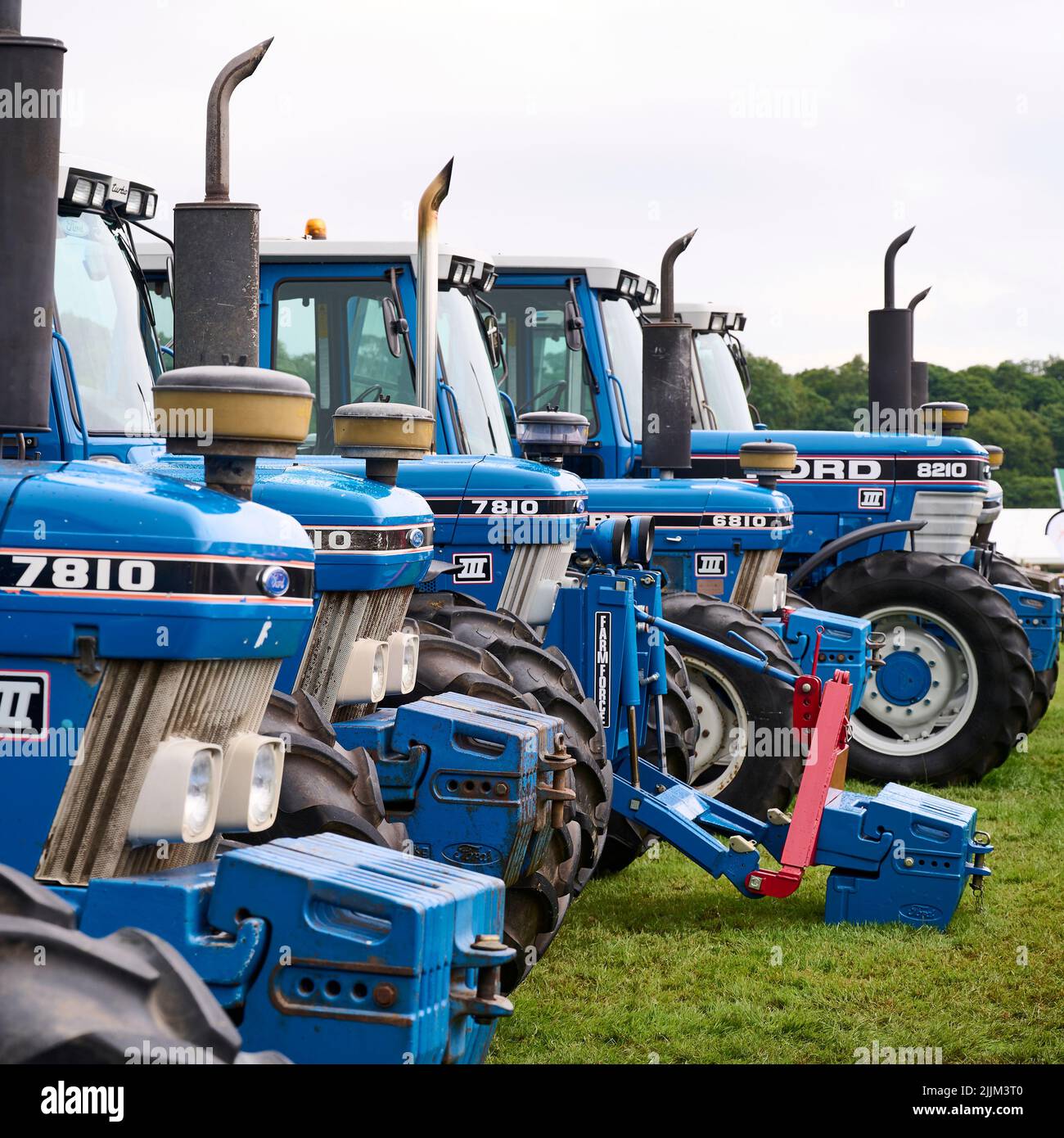 Row of blue Ford tractors on display at county agricultural show Stock