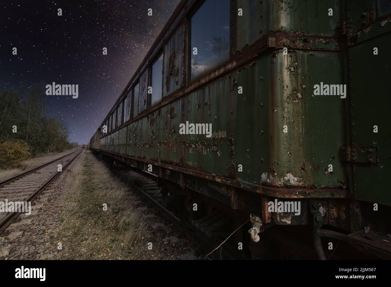 The old dark green train car against the background of starry sky. Stock Photo