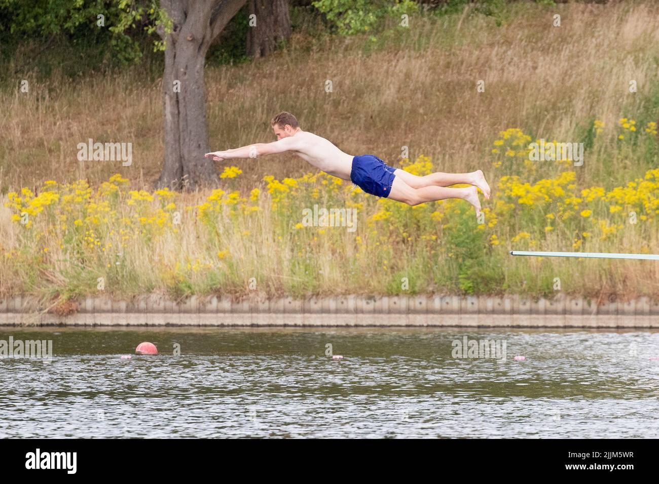 London ,United Kingdom  -27/07/2022. .A man dives into the Mens Ponds on a dry Hampstead Heath, North London as the UK could face a Drought if extreme Stock Photo