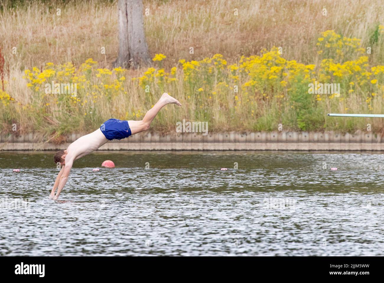 London ,United Kingdom  -27/07/2022. .A man dives into the Mens Ponds on a dry Hampstead Heath, North London as the UK could face a Drought if extreme Stock Photo