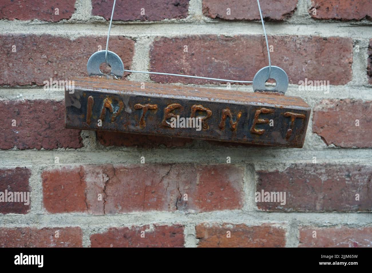 An old sign of Internet hanging from a brick wall Stock Photo