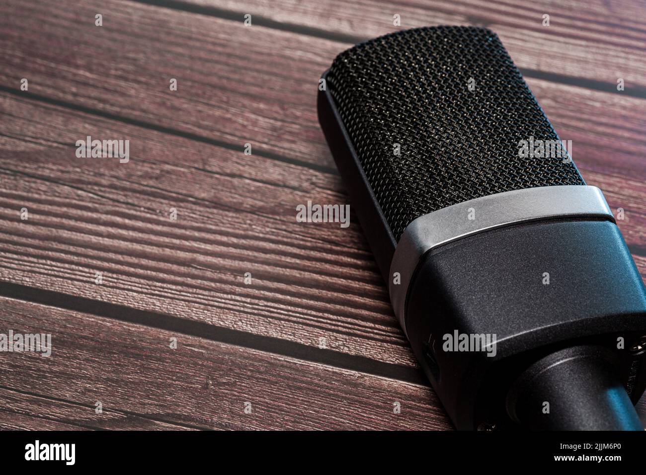 A High Quality condenser Microphone on wood background with black color