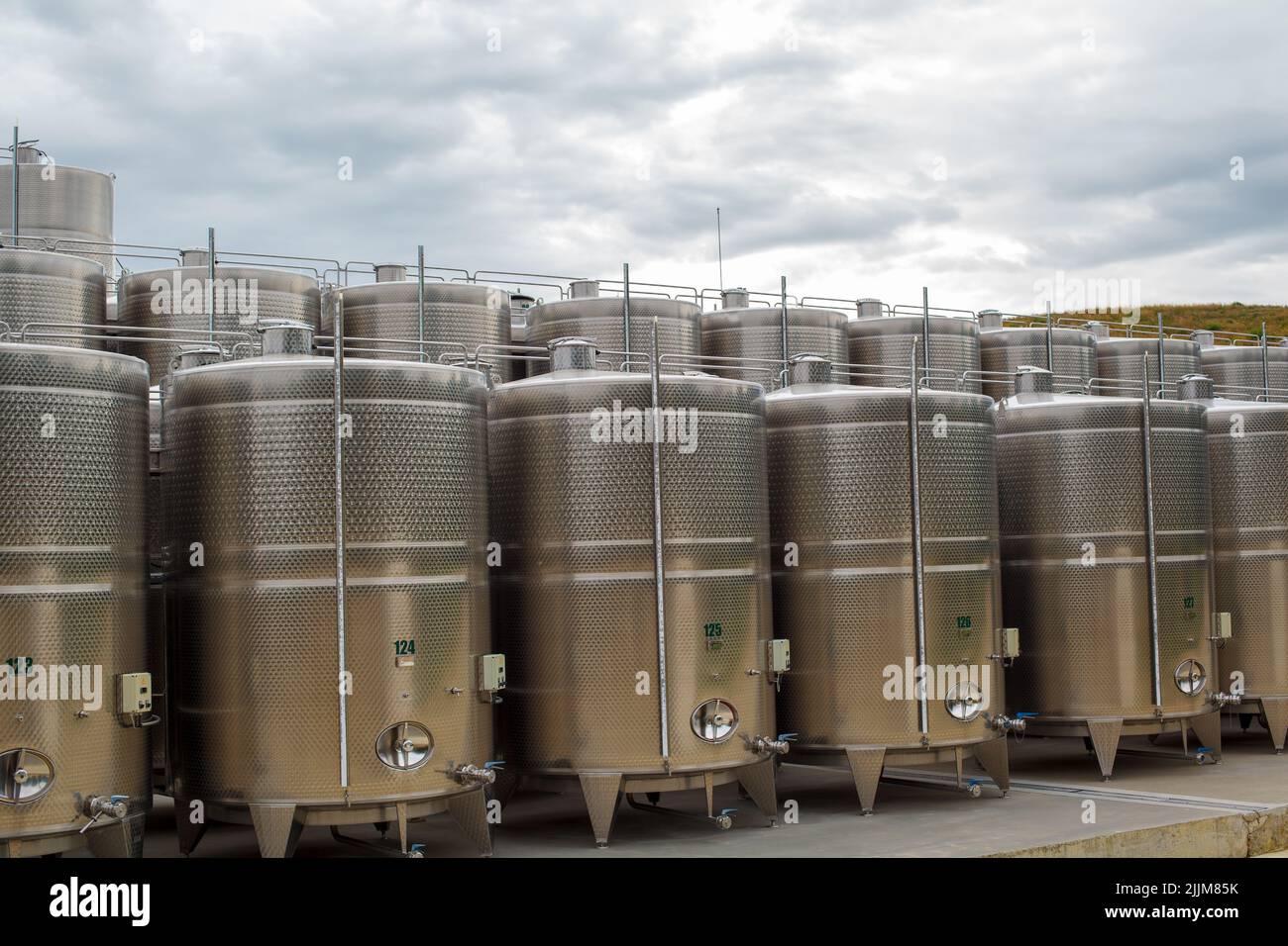 A scenery of stainless steel containers under a cloudy sky Stock Photo