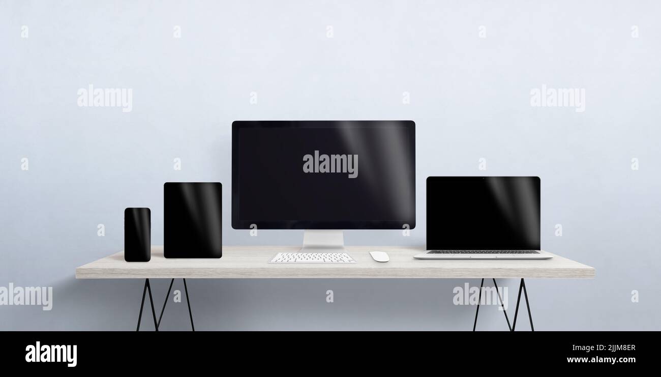 Turned off devices of different sizes on the desktop. Blank screen for responsive web page or app promotion. Computer display, laptop, tablet and smar Stock Photo