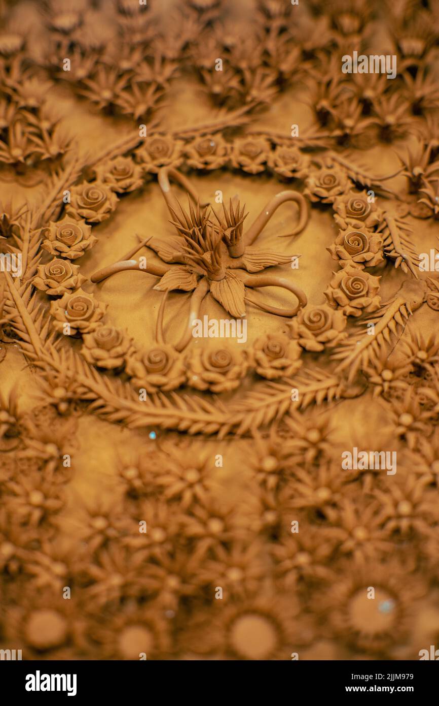 A vertical closeup shot of rose flower Thai style teak wood carving Stock Photo