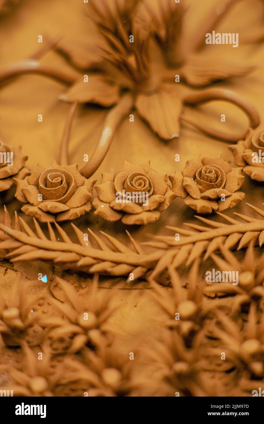 A vertical closeup shot of rose flower Thai style teak wood carving Stock Photo