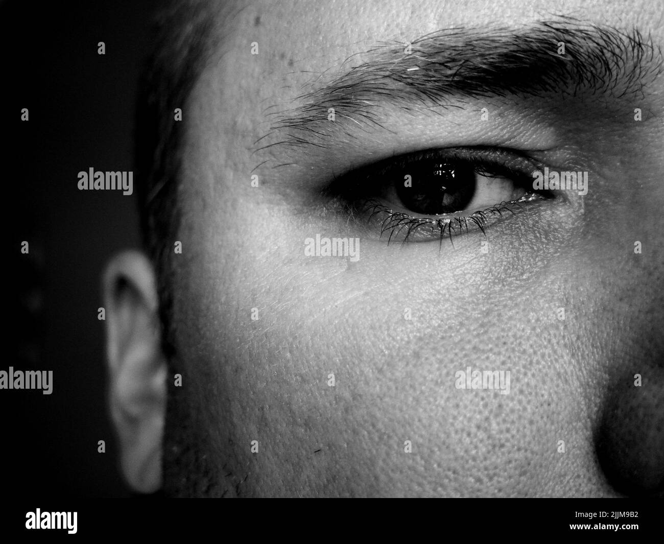 A grayscale closeup of the man's eye. Stock Photo