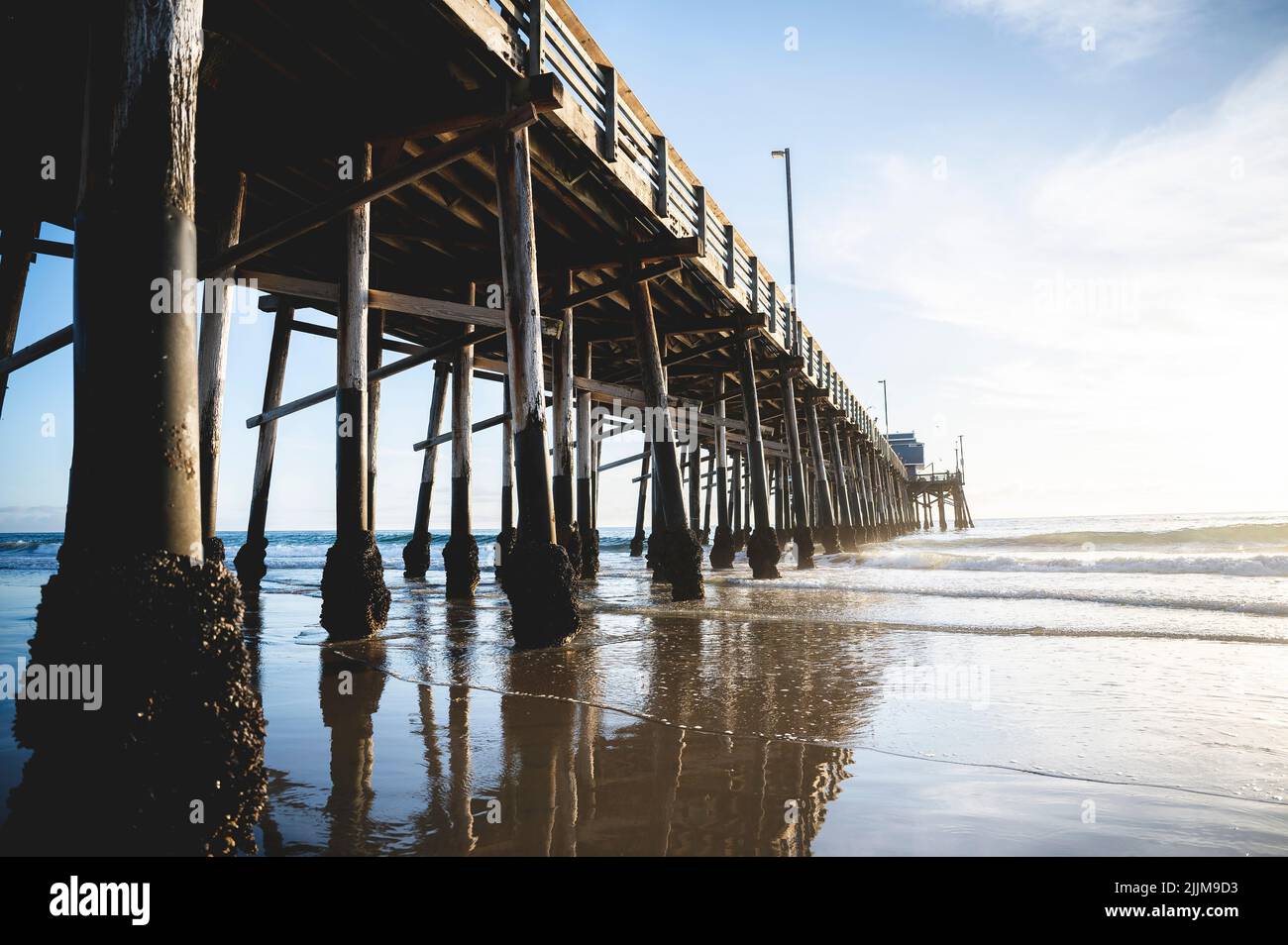 A low angle shot of a beach pier under the cloudy skies Stock Photo - Alamy