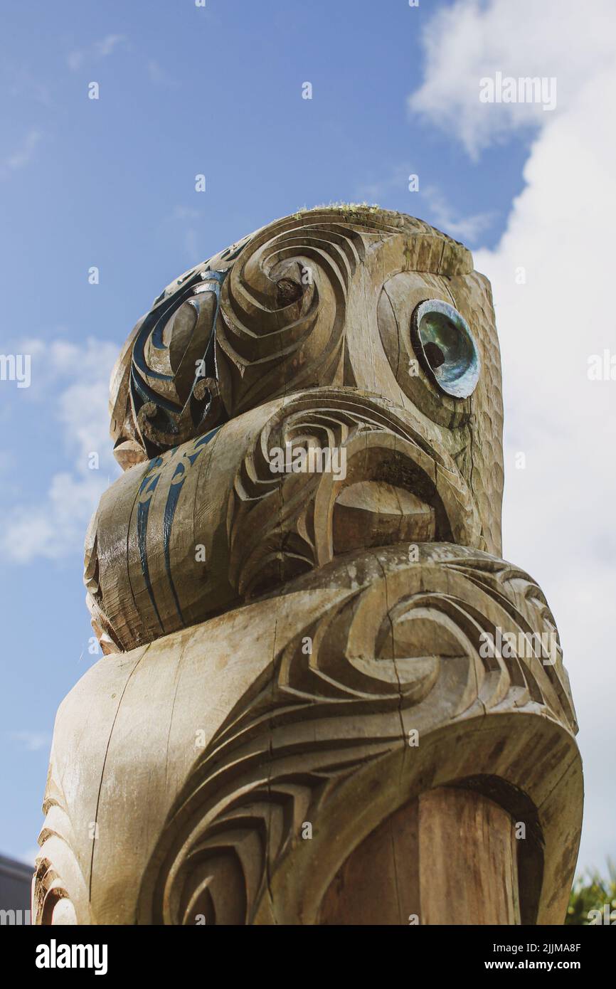 A vertical shot of Maori wooden curved sculpture in New Zealand Stock