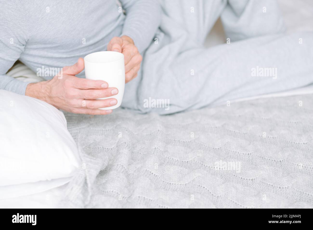 comfort morning beverage man bed hold cup Stock Photo
