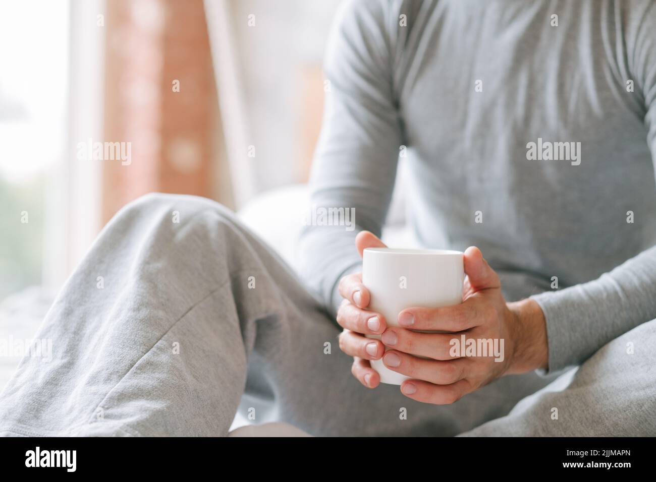 comfort morning beverage man sit hold cup Stock Photo