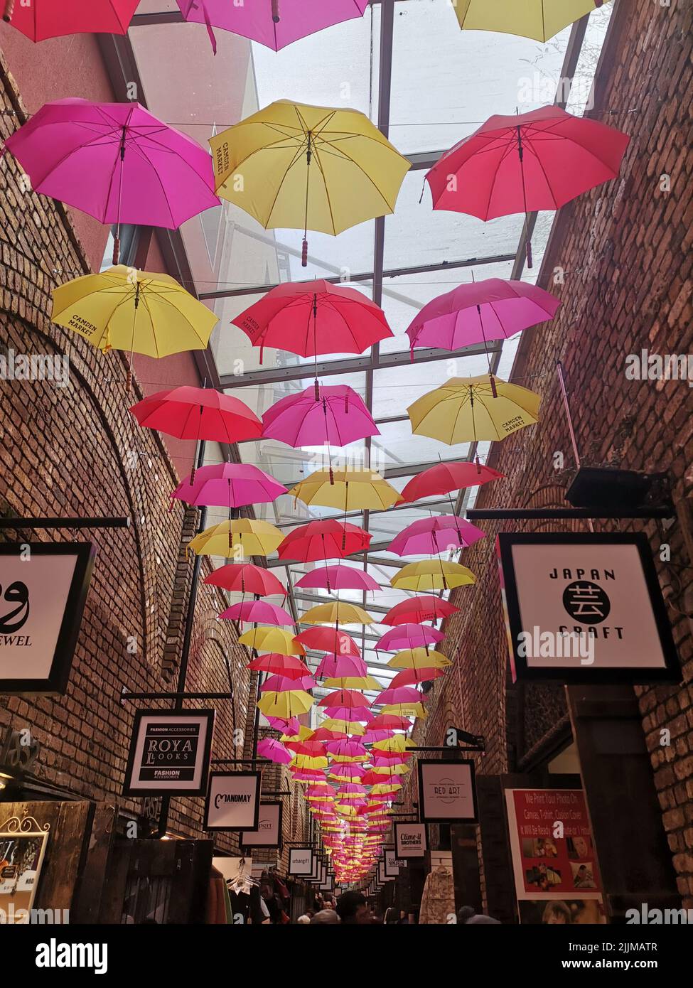 A vertical shot of a Camden market with colorful umbrella decorations ...
