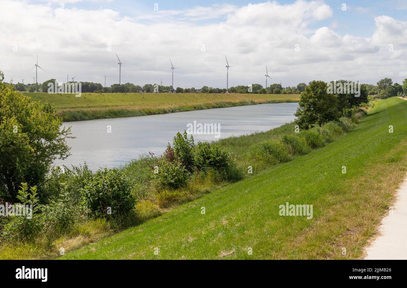 View from the dike to the Hooksieler inland low, called Hooksmeer, with windmills in the background. It´s a district of Wangerland in Lower Saxony, Ge Stock Photo