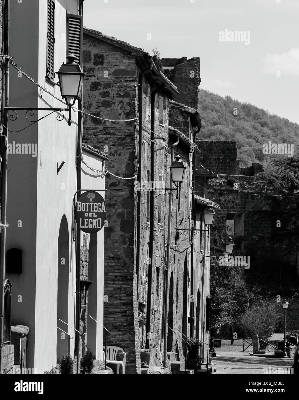 A grayscale vertical shot of a street and buildings of Sovana Maremma in Tuscany, Italy Stock Photo